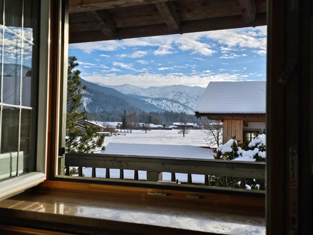 una finestra con vista su una montagna innevata di Ferienwohnung Rebensburg a Point
