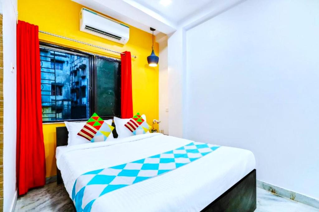 a bedroom with a large bed with a window at Hotel M M Howrah Maidan Home Stay Inn Kolkata in Hāora