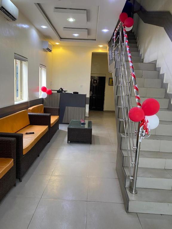 a lobby with a staircase with red and white balloons at Hope Residence hotel and suite in Lagos
