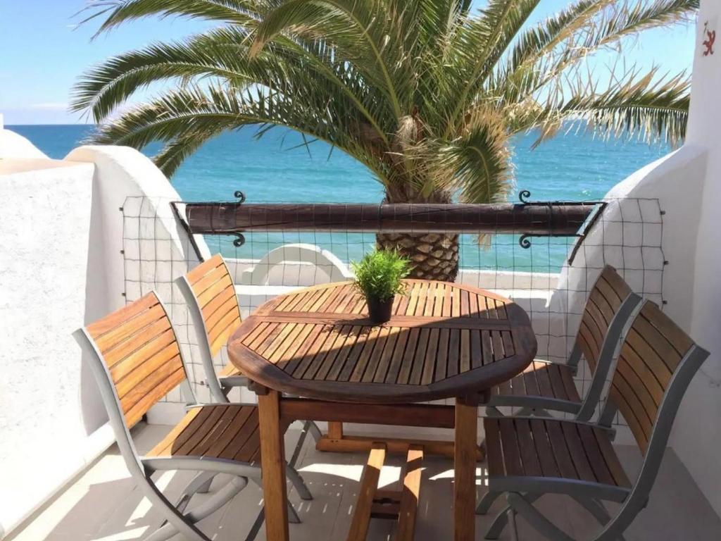 uma mesa e cadeiras numa varanda com uma palmeira em Apartment Raco em Barcelona