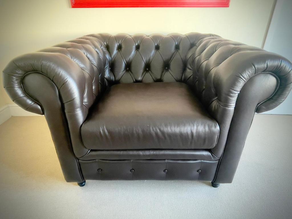 un sofá de cuero marrón sentado en una habitación en 83 Eastlake drive en Ciudad del Cabo