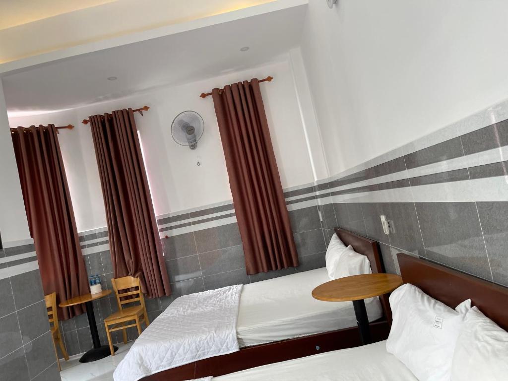 una camera d'albergo con due letti e un tavolo di VIEW HOTEL-TRÀM CHIM a Tràm Chim