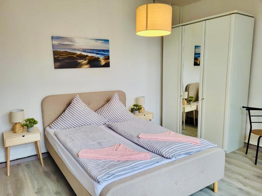 a bedroom with a bed with two pink pillows at Haus Deitje in Borkum