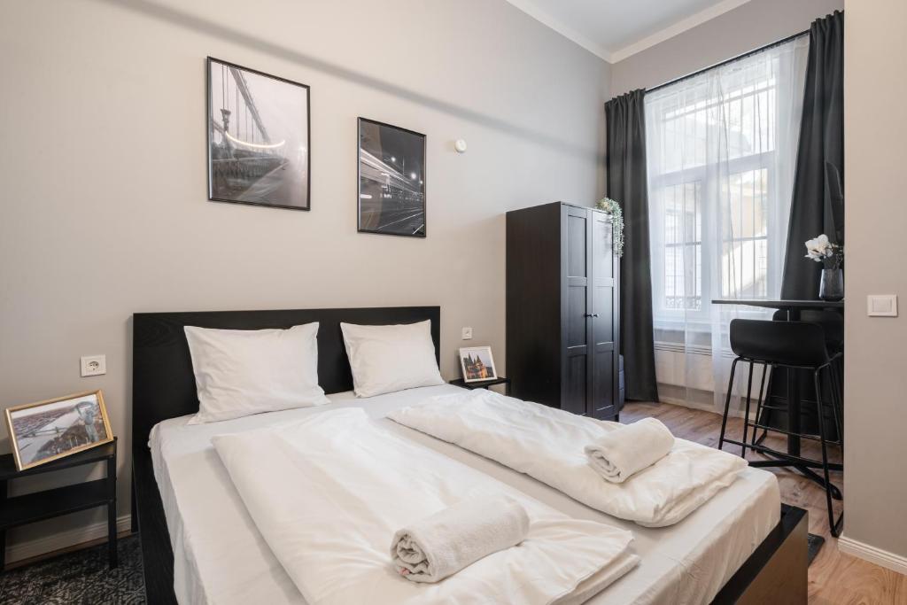 een slaapkamer met een groot wit bed met 2 kussens bij R38 Boutique Apartments, Best Location by BQA in Boedapest