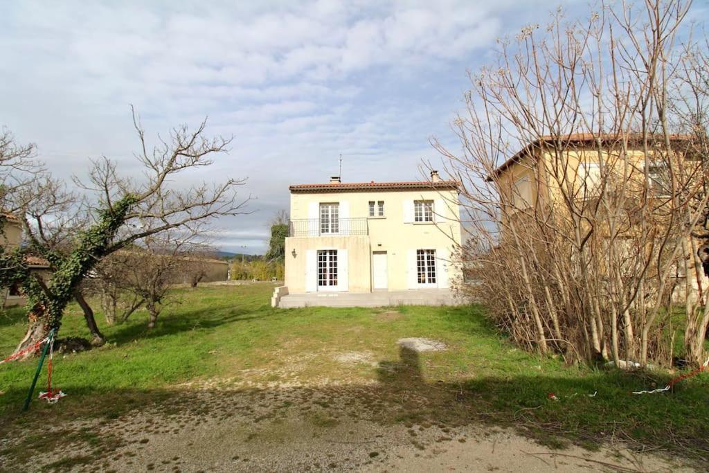 a large white house in a field with trees at Luberon Large House 4 bedrooms in La Tour-dʼAigues