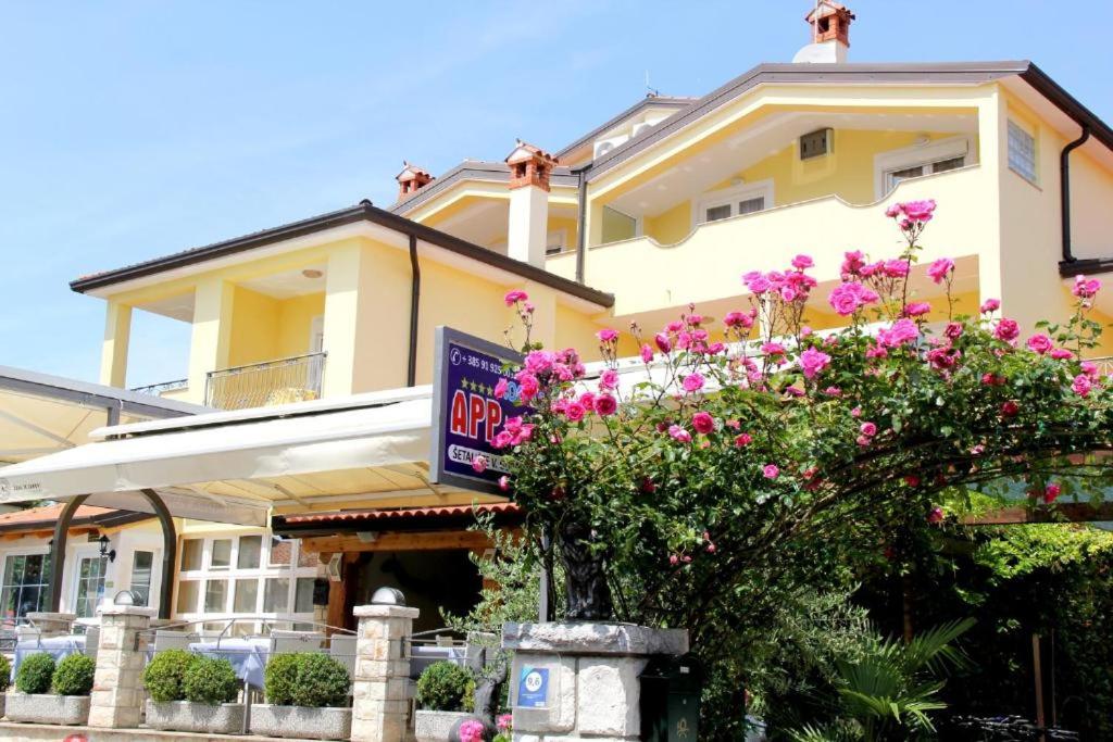 un edificio con fiori rosa di fronte di Appartmani Punta a Umag (Umago)