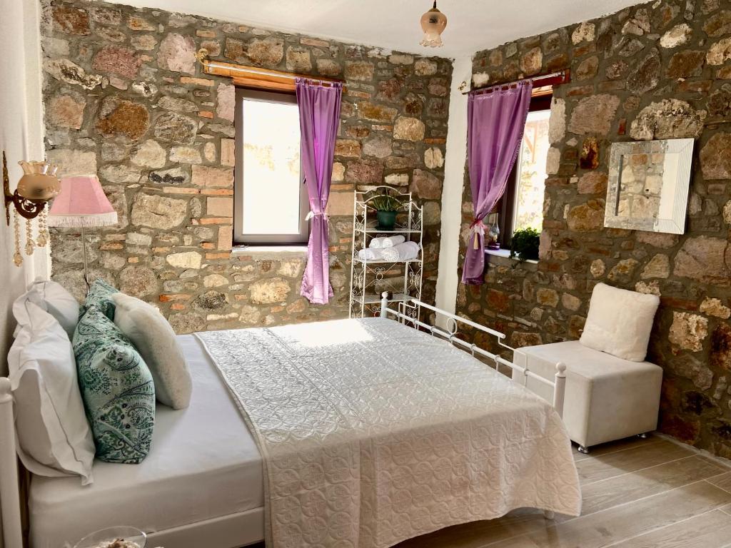- une chambre avec un lit et un mur en pierre dans l'établissement Masal Küçükköy Boutiquehotel, à Ayvalık
