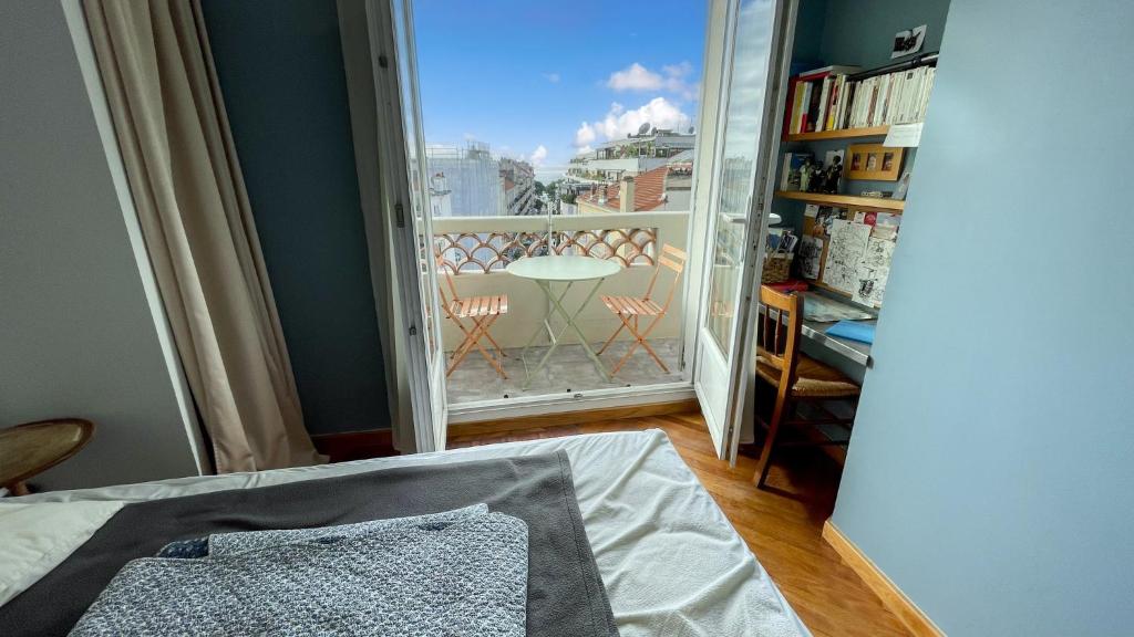 1 dormitorio con 1 cama y ventana con balcón en Rue Hoche Cannes 2 room apartment very quiet, en Cannes