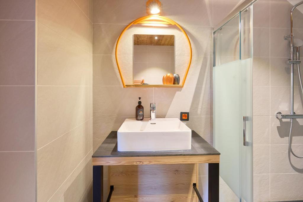 a bathroom with a white sink and a shower at Hotel Base Camp Lodge - Albertville in Albertville