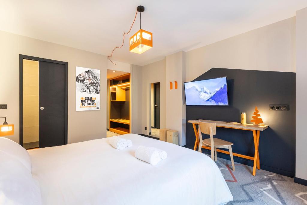 a bedroom with a large white bed and a desk at Hotel Base Camp Lodge - Albertville in Albertville