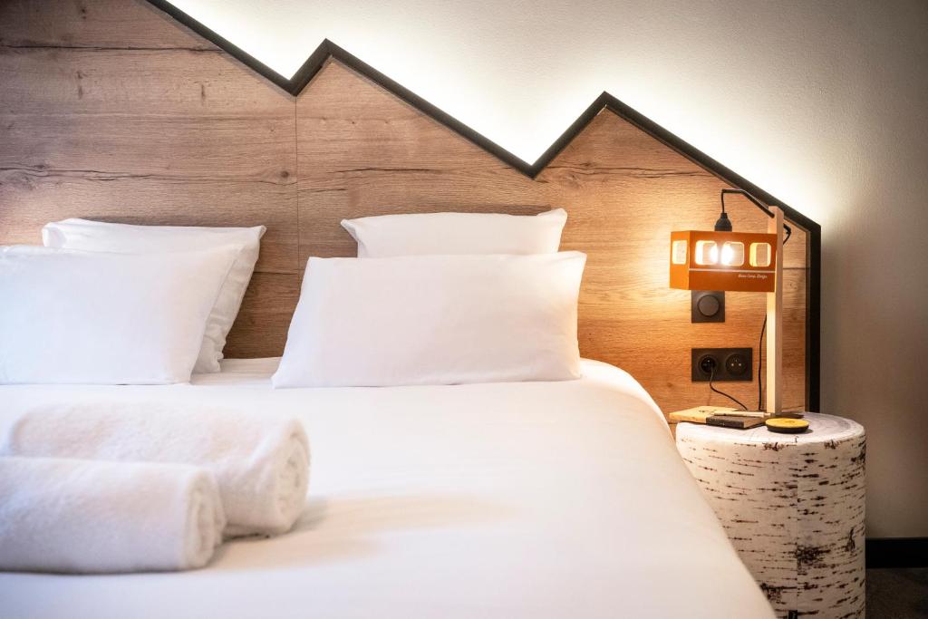 a bedroom with two beds with white pillows and a lamp at Hotel Base Camp Lodge - Albertville in Albertville