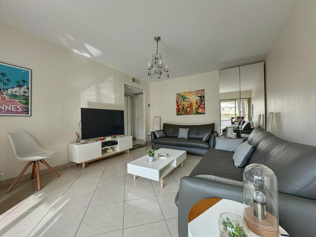 un salon avec un canapé et une télévision dans l'établissement Appartement proche CARLTON, à Cannes