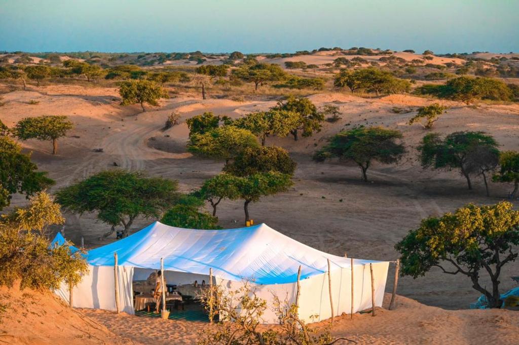 une tente bleue et blanche au milieu d'un désert dans l'établissement Camp Rêve de Nomade, à Lompoul