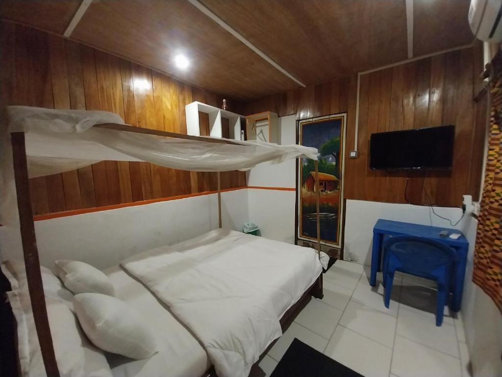1 dormitorio con litera y mesa azul en Orange Beach hostel, en Cape Coast