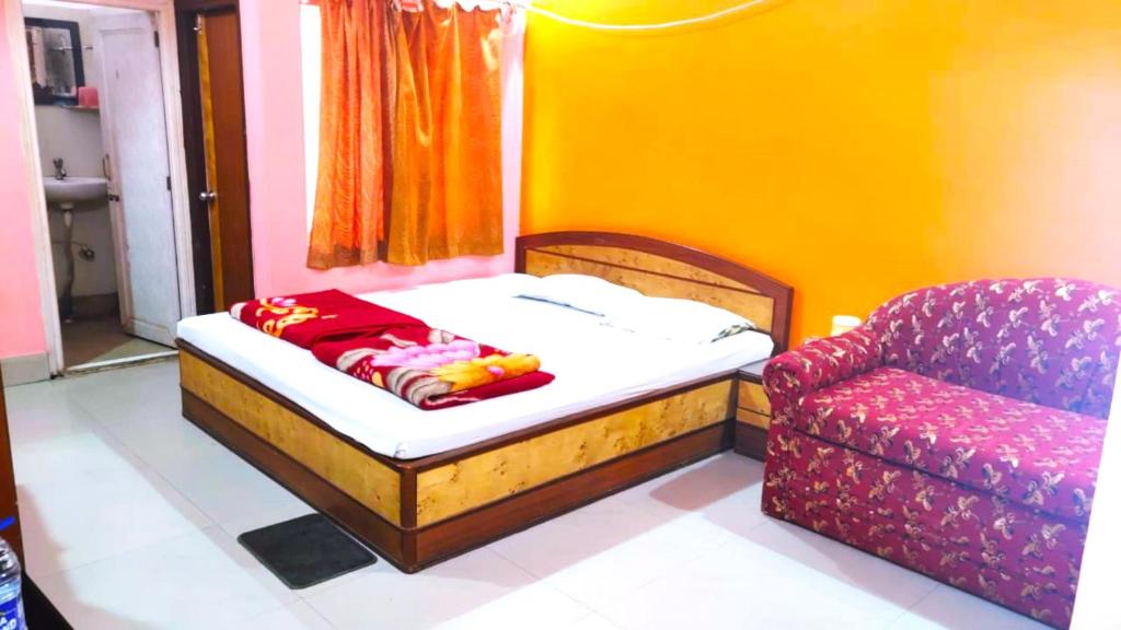 a small bedroom with a bed and a couch at Hotel Sunny New Digha Near Sea Beach View Point - Couple Friendly in Digha