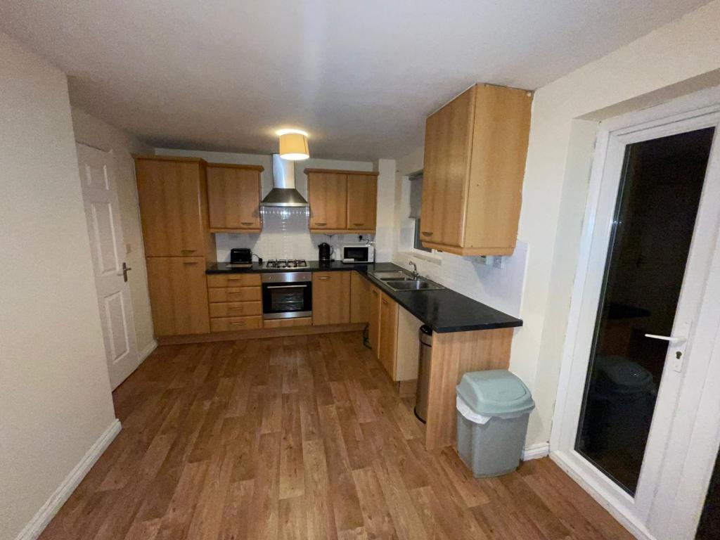 - une cuisine avec des placards en bois et un comptoir dans l'établissement Room 4 - Chassagne Guest House, à Church Coppenhall