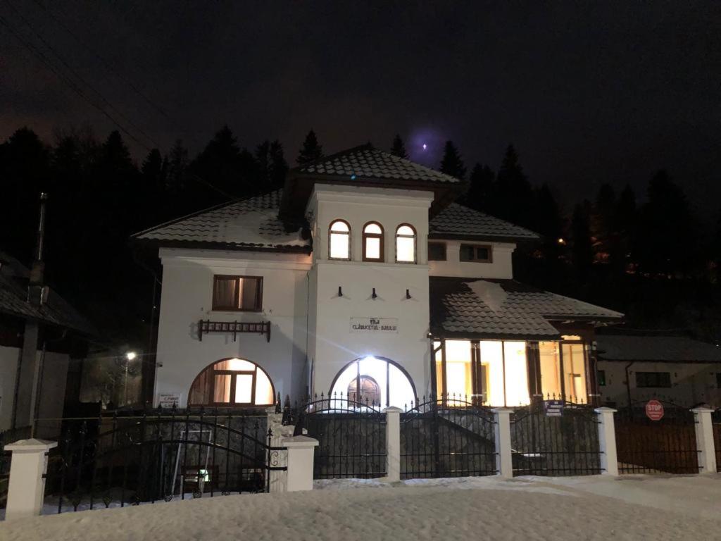 ein großes weißes Haus mit Lichtern in der Nacht in der Unterkunft Vila Clabucetul Baiului in Buşteni