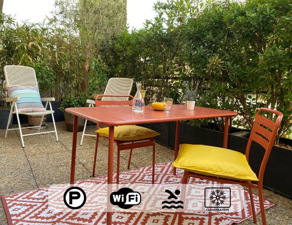 une table et des chaises en bois sur une terrasse dans l'établissement Ma place au sud Aix Terrasse Parking, à Aix-en-Provence
