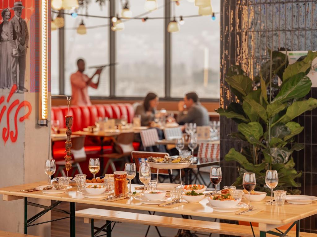 a dining room with tables and people in a restaurant at Eklo Paris Expo Porte de Versailles in Vanves