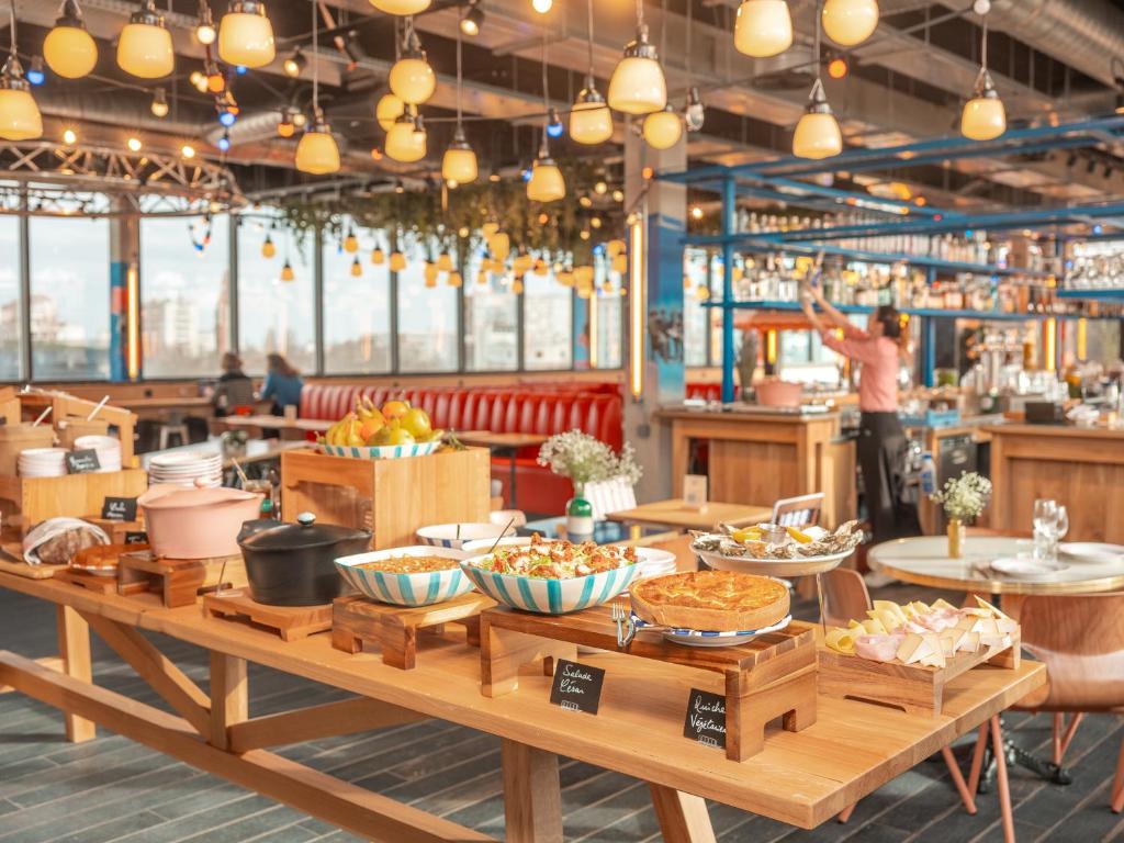 a table with bowls of food on it in a restaurant at Eklo Paris Expo Porte de Versailles in Vanves