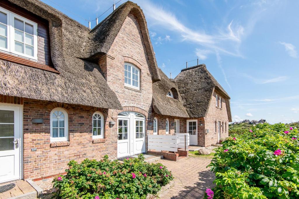 an old brick house with a thatched roof at Haus Raanwai Whg 3a in Rantum