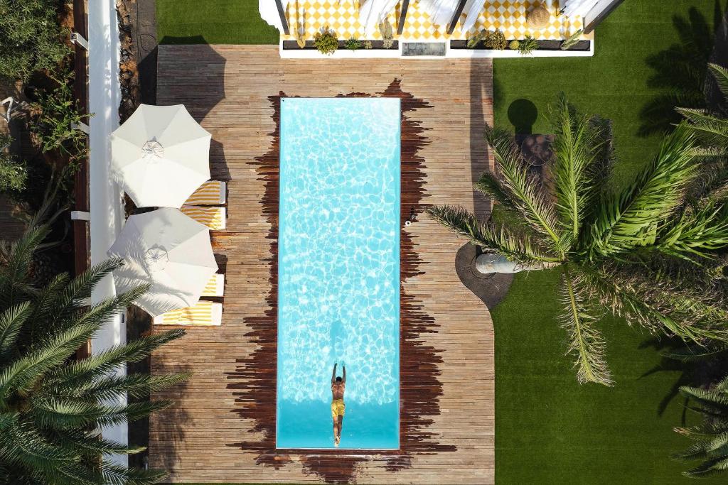 an overhead view of a swimming pool with a person in it at UNIQUE Villas Lajares - Only Adults in Lajares