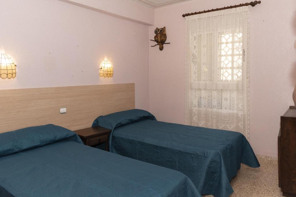een kamer met 2 bedden en een raam bij Amador, 3º-J in Cullera