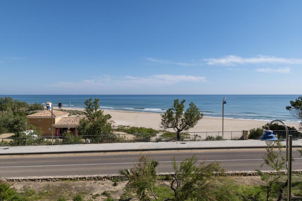 a road next to a beach with the ocean at Hawai Bajo in Faro de Cullera