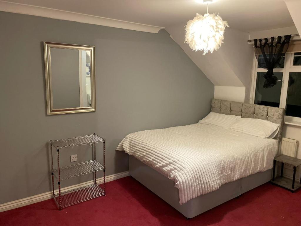 um quarto com uma cama com um espelho e um lustre em Room 5 - Chassagne Guest House em Church Coppenhall