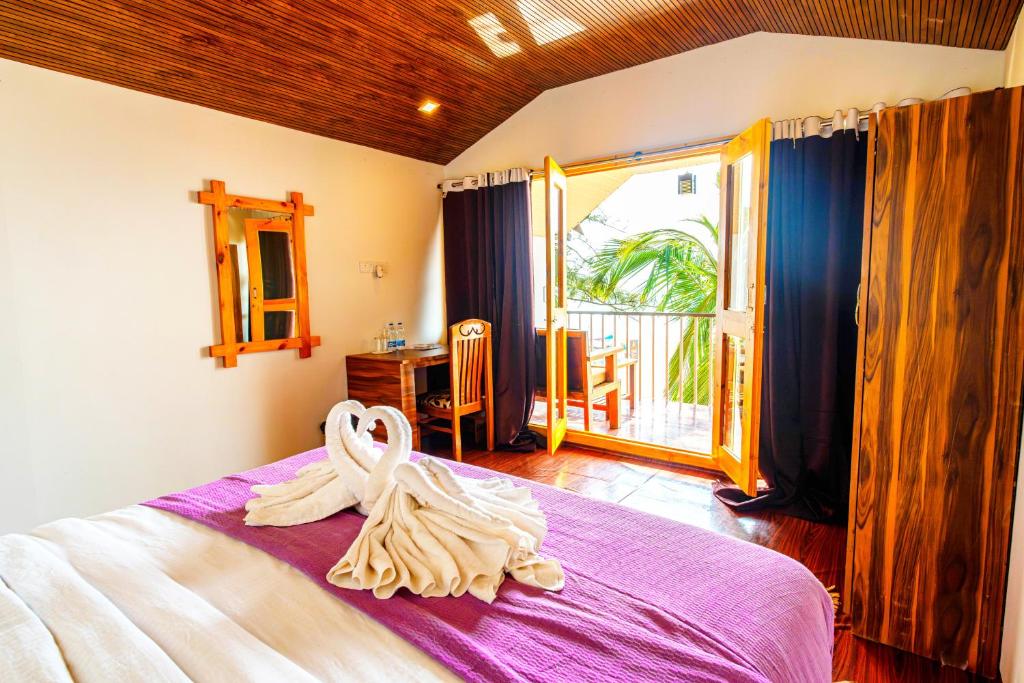 a bedroom with a bed with a towel on it at Agonda Serenity Resort in Agonda