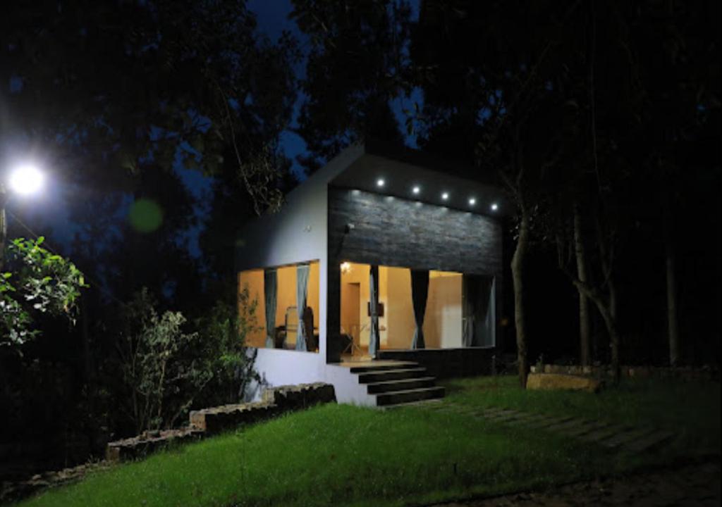 una pequeña casa por la noche con luces encendidas en Blue Valley Estate-12 Acre Forest-Silver Oak-Villa, en Yercaud