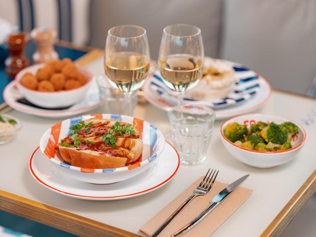 a table with plates of food and glasses of wine at Eklo Paris Expo Porte de Versailles in Vanves