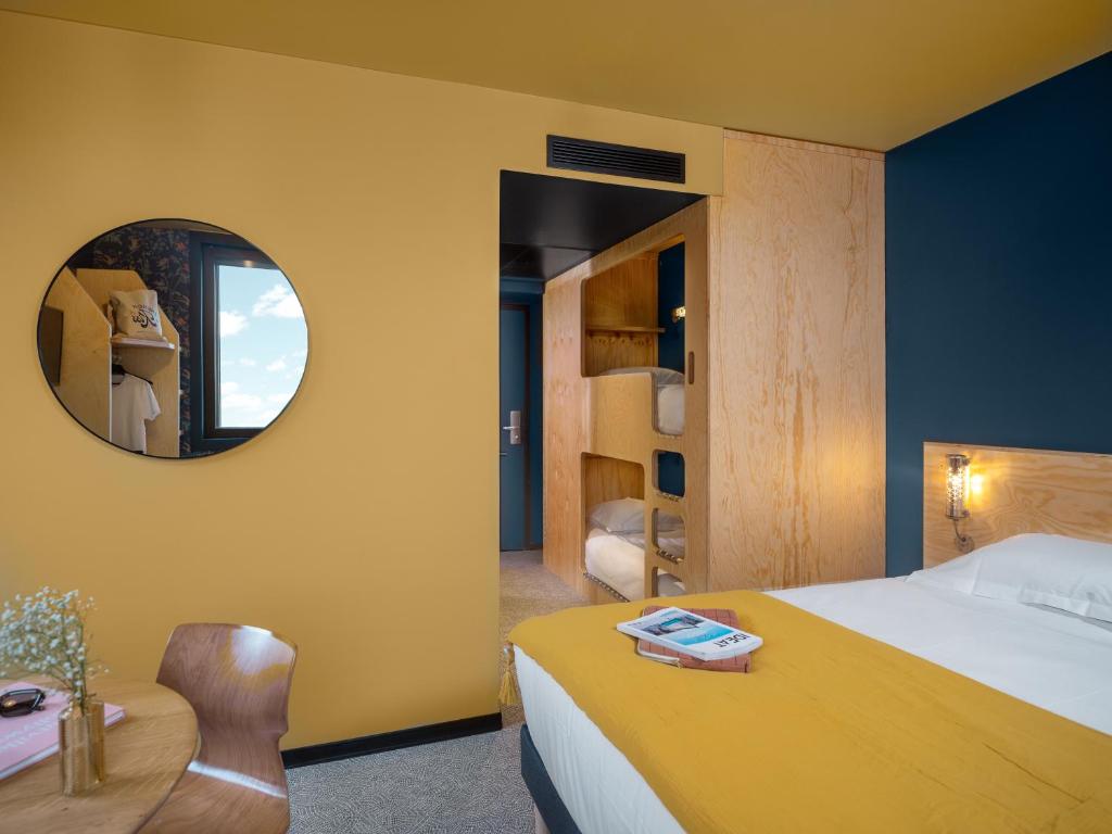 a hotel room with a bed and a mirror at Eklo Paris Expo Porte de Versailles in Vanves