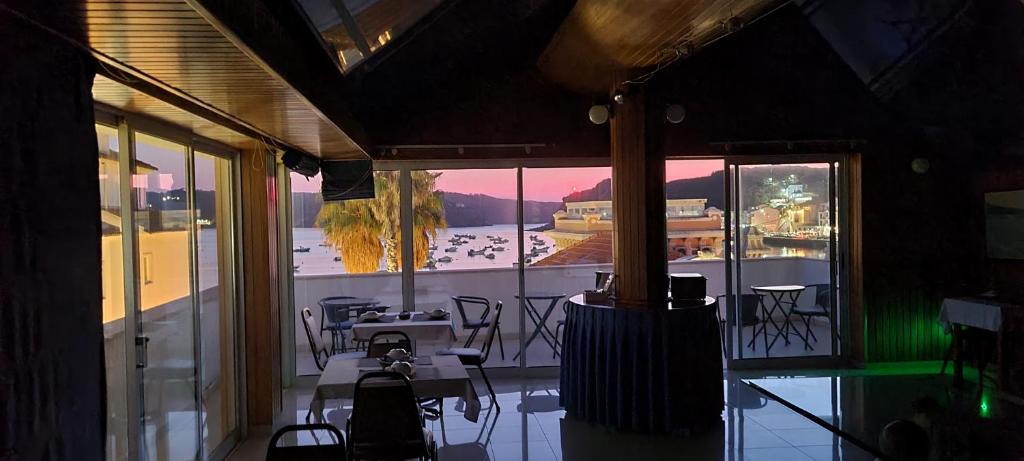 a room with a large window with tables and chairs at Albergaria Sao Pedro in São Martinho do Porto