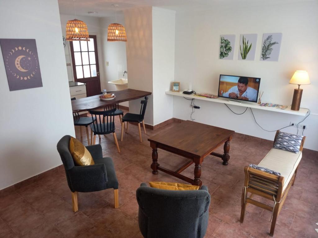 a living room with a table and chairs at Departamento dos dormitorios con cochera Tres Arroyos -3- in Tres Arroyos