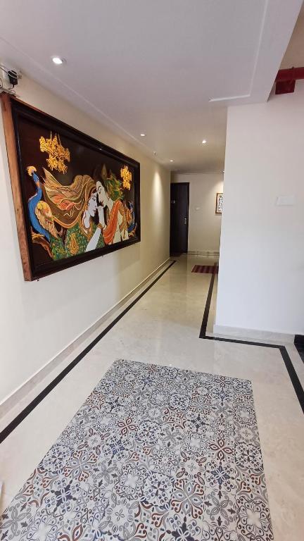 a hallway with a large painting on the wall and a rug at Sridham in Puri