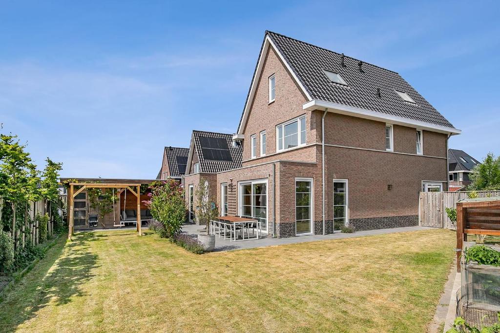 a large brown brick house with a yard at Vakantiehuis - Albert Aylerstraat 10 - Middelburg in Middelburg