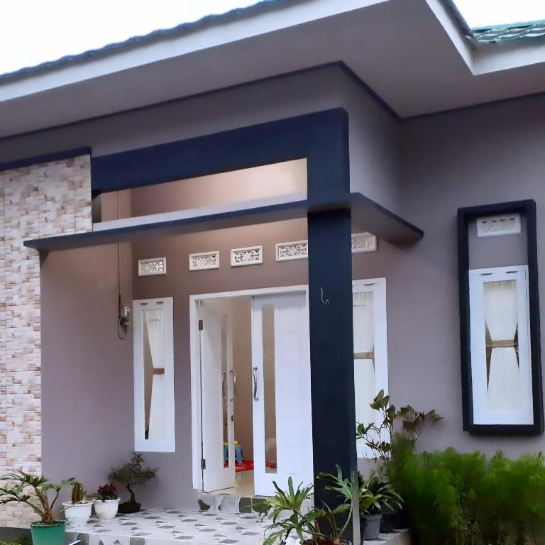 une maison avec une porte d'entrée bleue dans l'établissement Rumah kinanti, à Diyeng