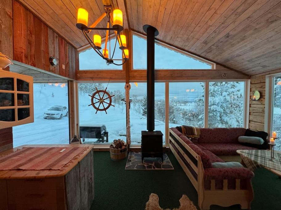 a living room with a couch and a large window at Cozy cabin HYLLA in Hamnvågnes
