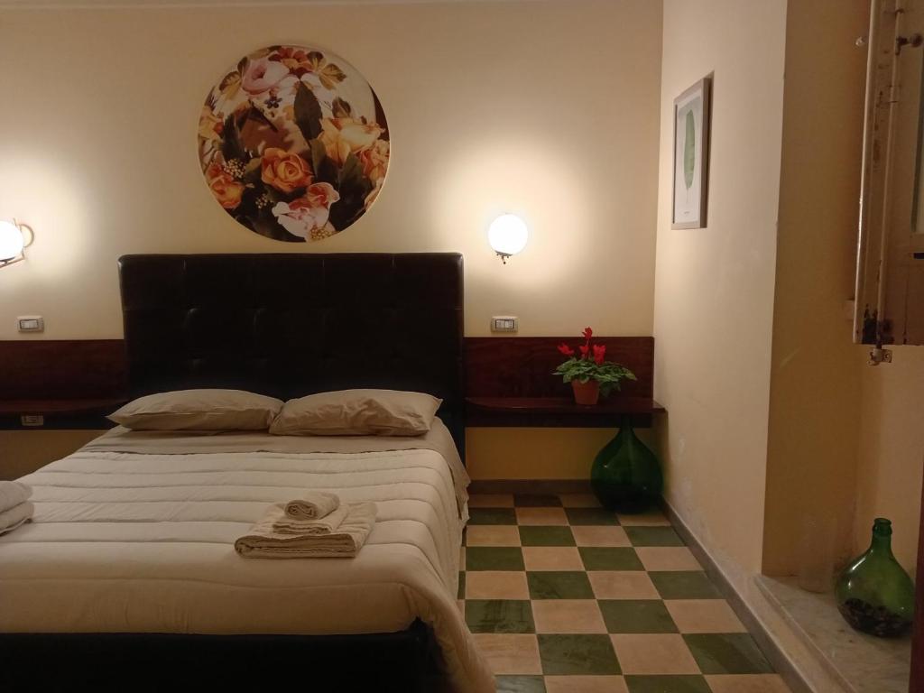 a bedroom with a bed with a checkered floor at Piazza Verdi Liberty House in Lecce