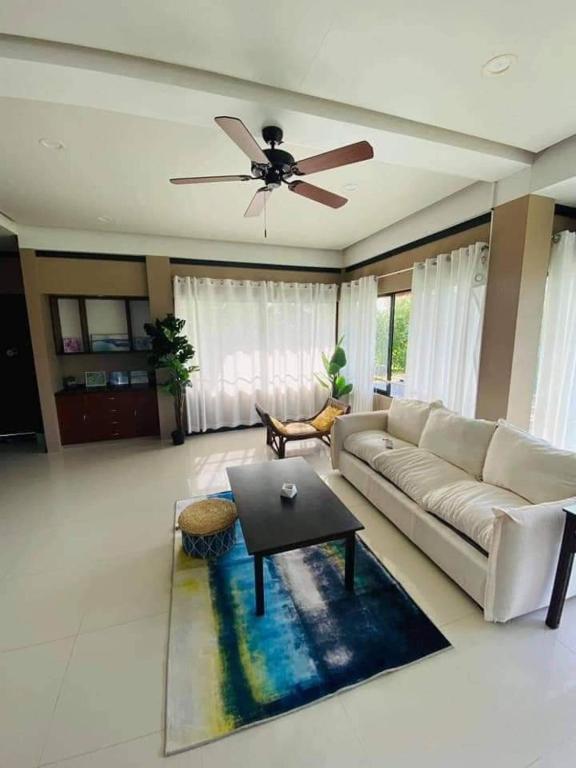 a living room with a couch and a ceiling fan at Seaheart Guesthouse in Dauis