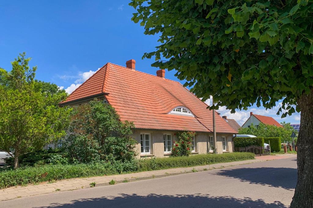 a house with an orange roof on a street at Ferienwohnungen Klein Kapelle in Gingst