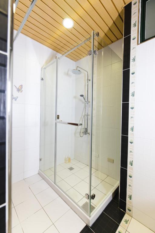 a shower with a glass door in a bathroom at Ho Feng Private Hotel 電梯自助民宿 in Ji&#39;an