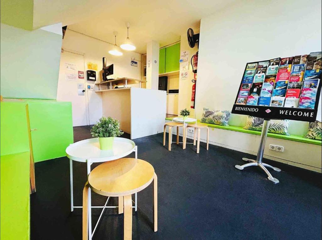 a waiting room with tables and chairs and a sign at Youth Hostel - Central and Basic Universitat in Barcelona