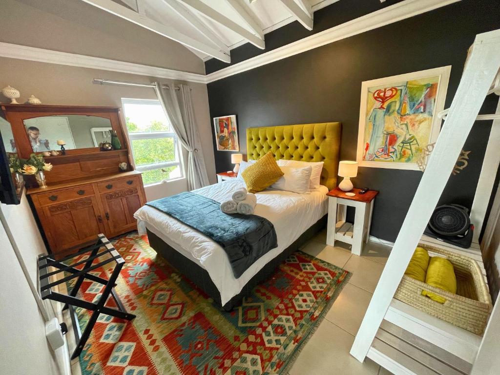 um quarto com uma cama king-size e um espelho em Calm Waters Guesthouse: Robberg Room em Plettenberg Bay