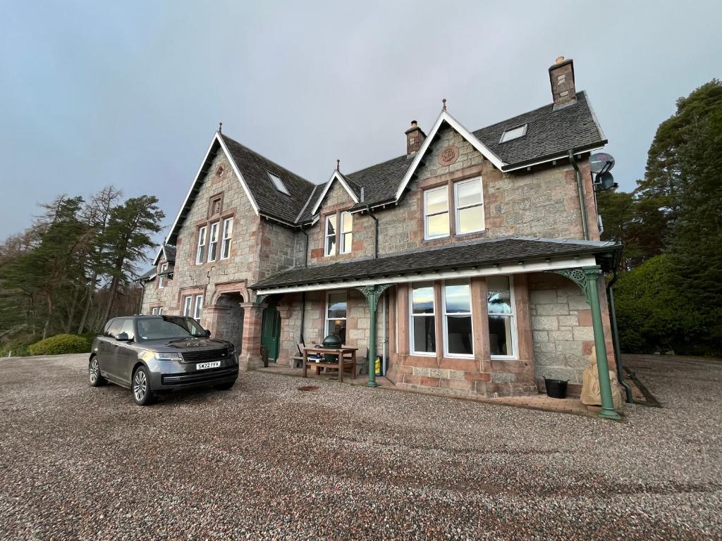 a car parked in front of a house at Tomdoun Estate in Invergarry