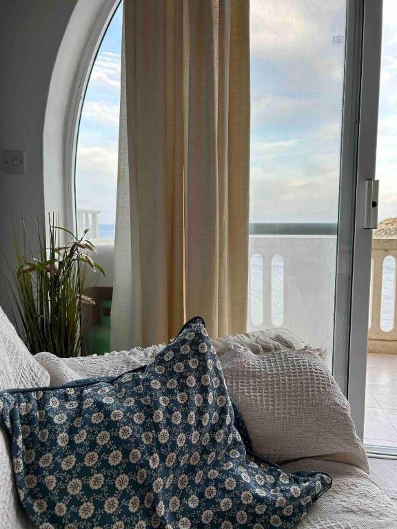 una almohada sentada en un sofá frente a una ventana en Excellent views, en Marsalforn