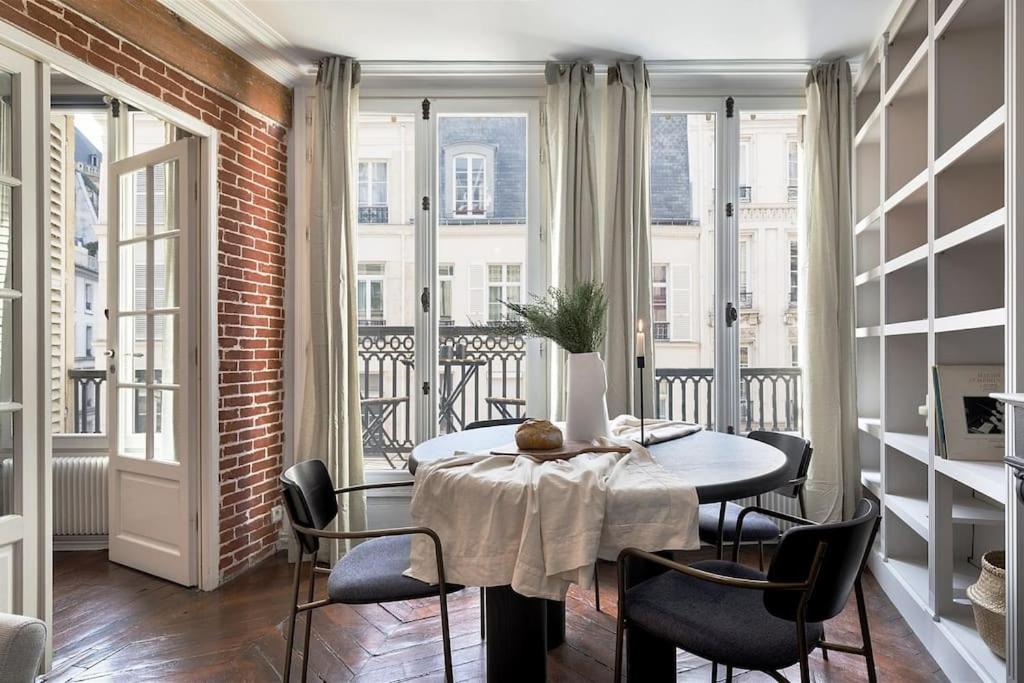 une salle à manger avec une table, des chaises et des fenêtres dans l'établissement Angers - 1 chambre et balcon aux Halles, à Paris