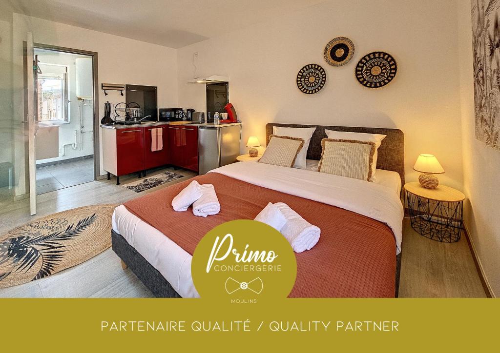 une chambre avec un grand lit et une cuisine dans l'établissement Joli studio Le Rosa Bonheur, proche de la gare, à Yzeure