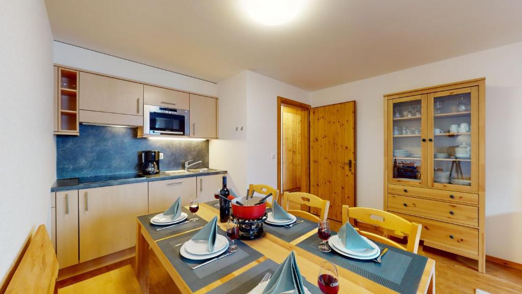 een keuken met een tafel en stoelen in een kamer bij Pracondu 1 404 - OUTDOOR & FUN charming apartment in Nendaz